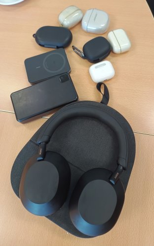 ヘッドフォンとイヤホンケース6個、バッテリーなどが並べられた様子